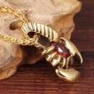 Pendentif acier dor� scorpion � pierre rouge